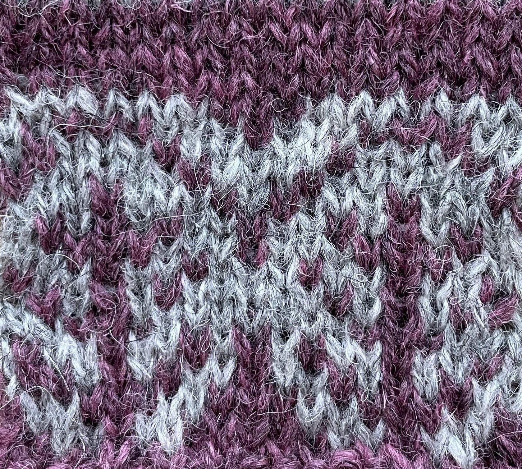 Close up of Pottery Tree Wrist Warmers and Cowl Pattern by Emma Vining. They have a knitted motif of a tiny tree within a white oval.