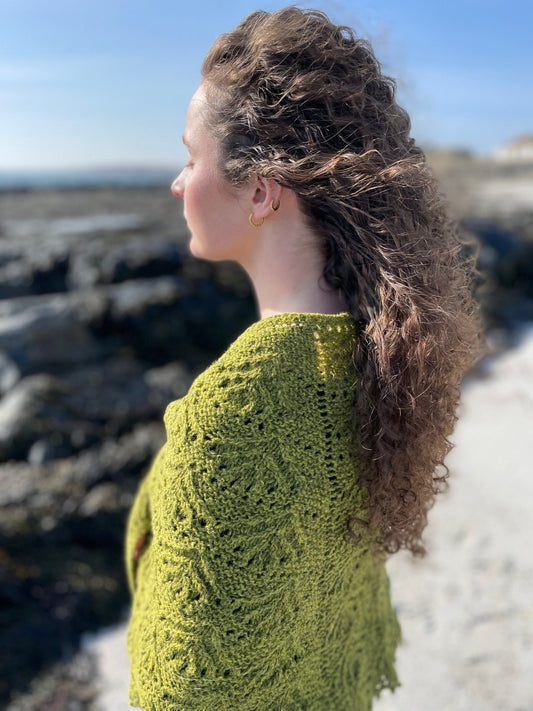 Beachcomber Shawl by Emma Vining. A green shawl, worn outside on the coast