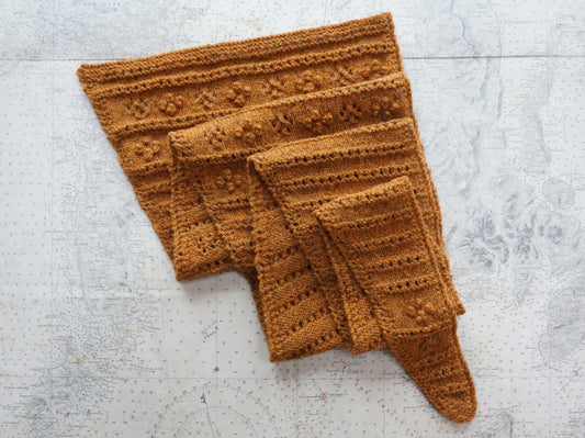 Machair Wildflower Shawl in orange yarn with lace eyelets and raised bobbles