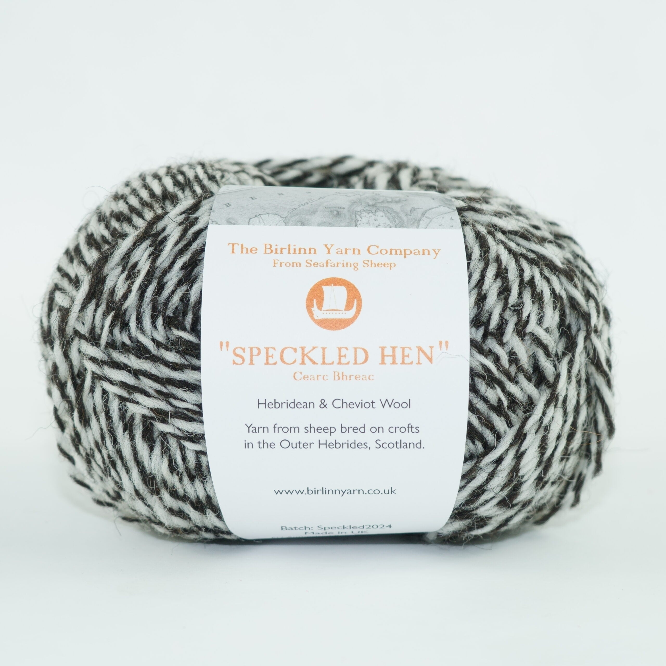 ball of Speckled Hen yarn with label: mix of whites and greys