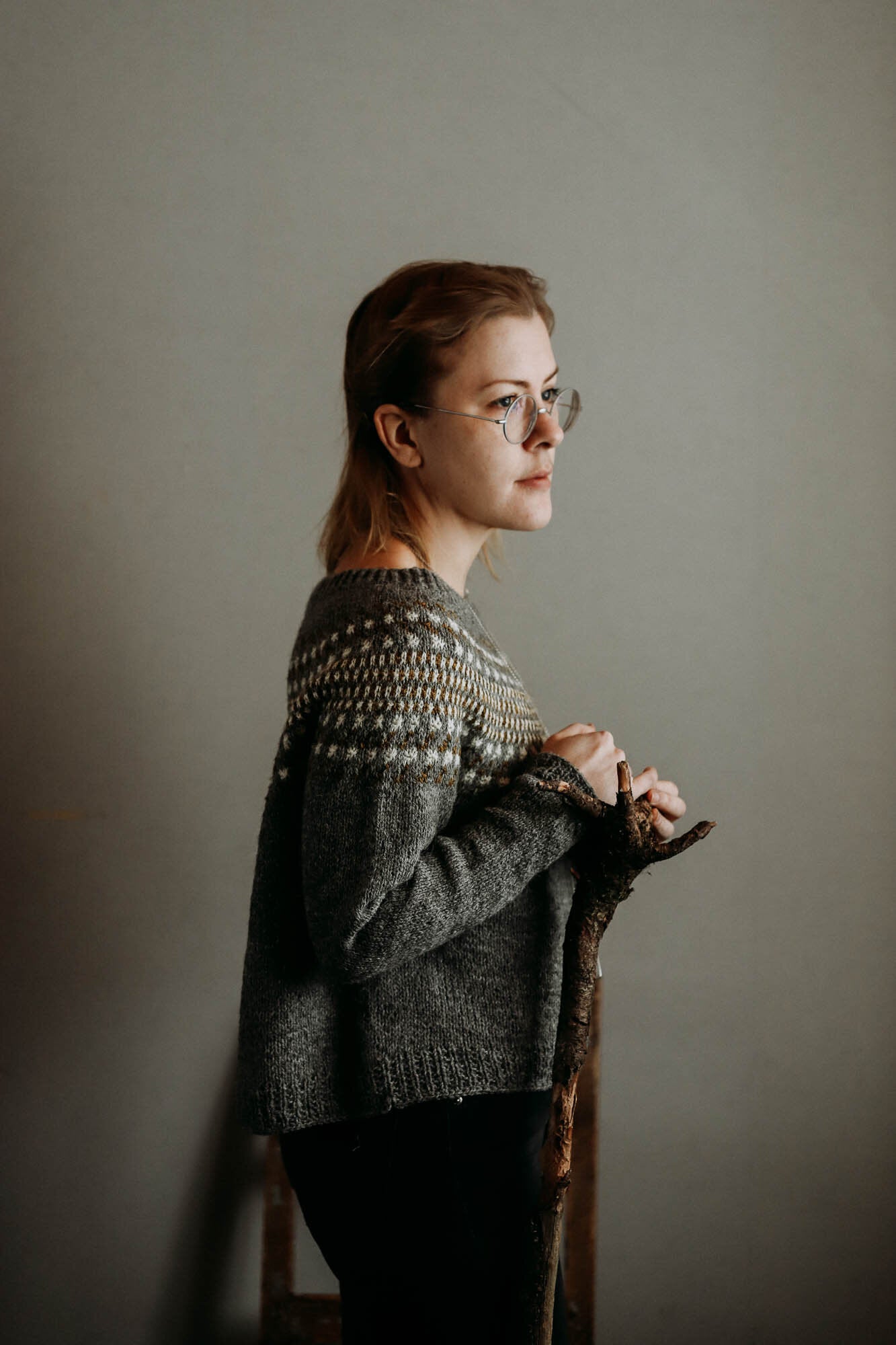 Waterlands sweater designed by Lotta Löthgren. A circular yoke jumper featuring an abstract colour work pattern. Knitted here in greys, white and browns.